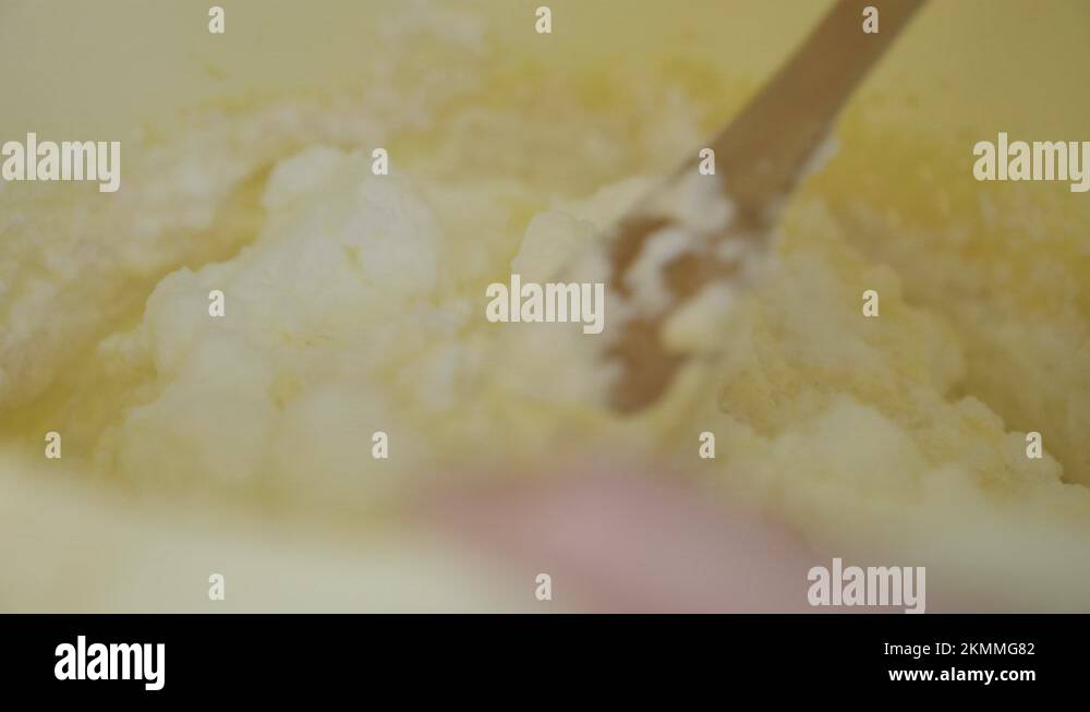 Beginner chef mixing batter and egg white foam in bowl with wooden
