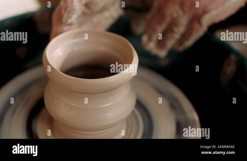 Potter shapes the clay product with pottery tools on the potter's wheel