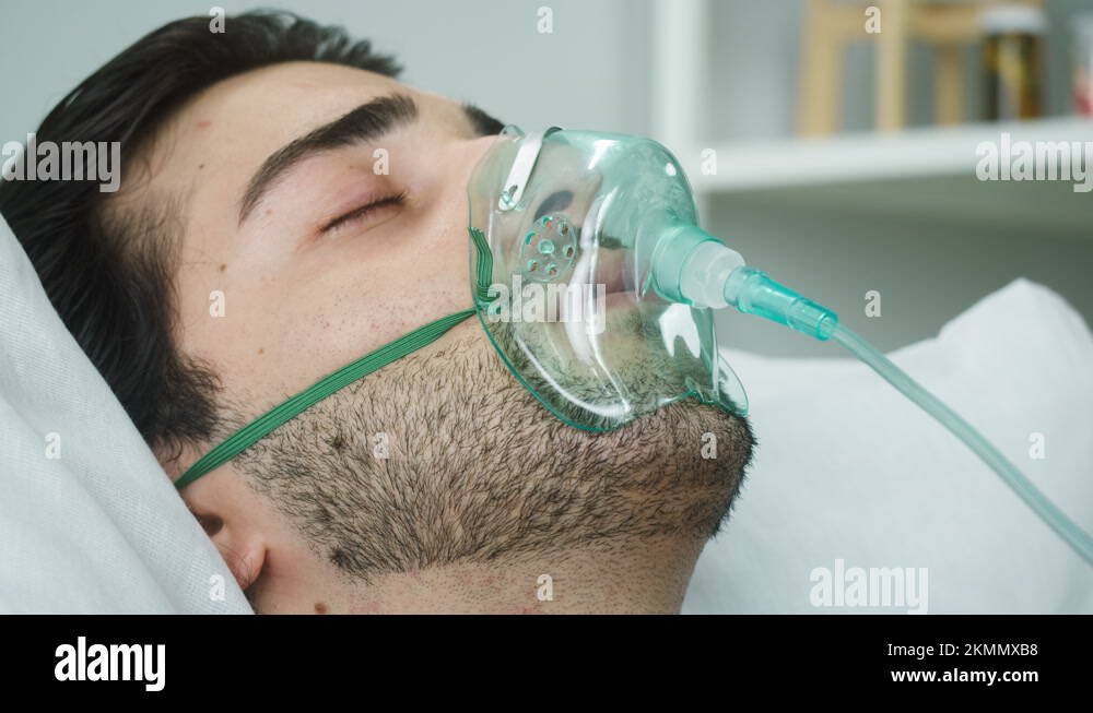 Sleeping patient lying with oxygen mask in reanimation, serious bad