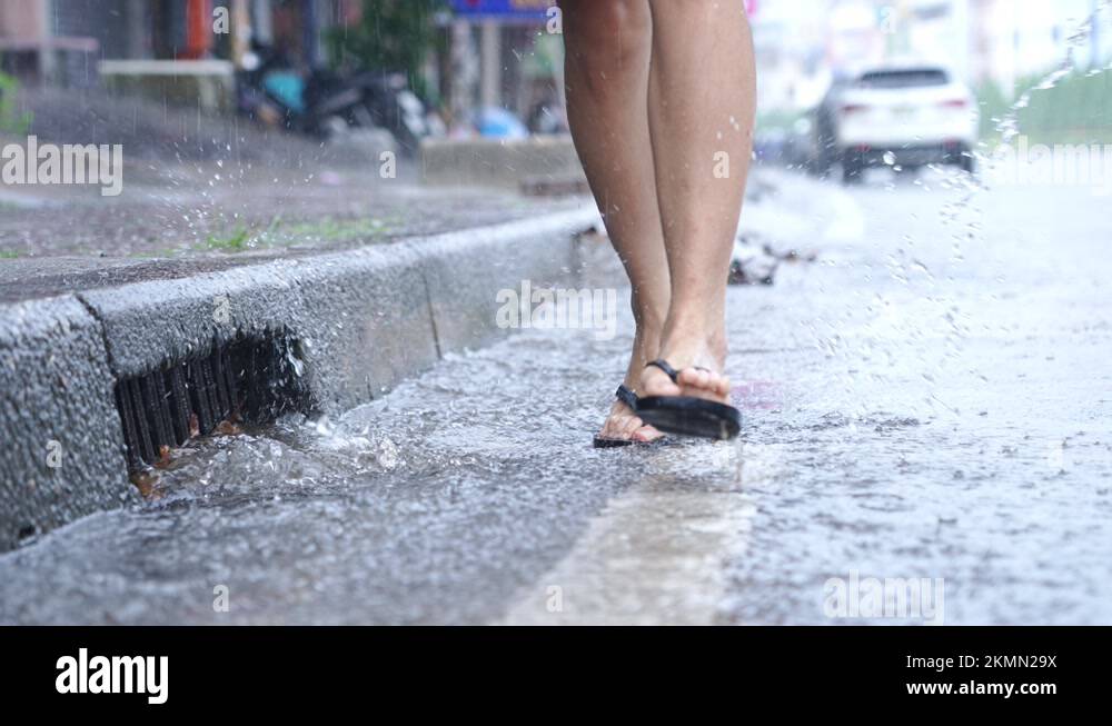Flopping Running A flip flop running on flooding roadside in raining day, water drainage ...