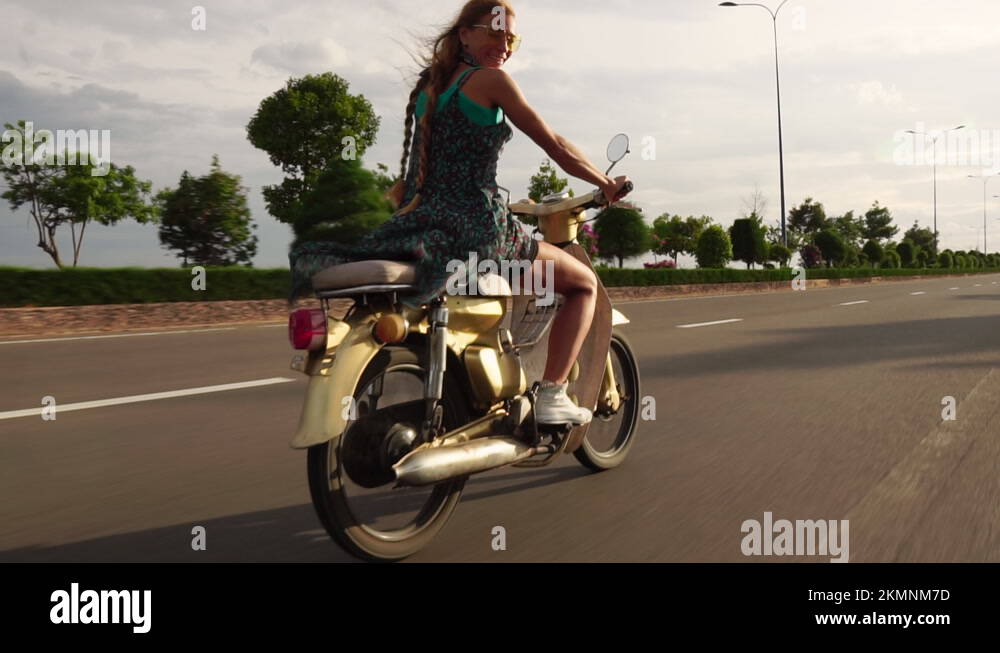 Woman Riding Motorbike In Slow Motion Along Highway Road In Slow Motion