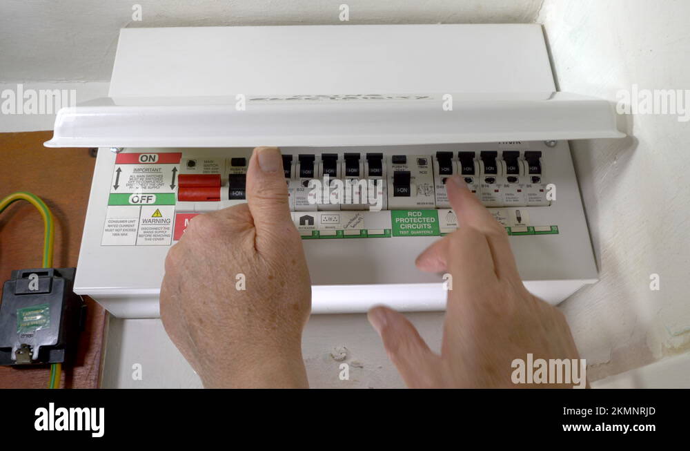 Man's hands switching off a power circuit in a mains electricity fuse box Stock Video Footage
