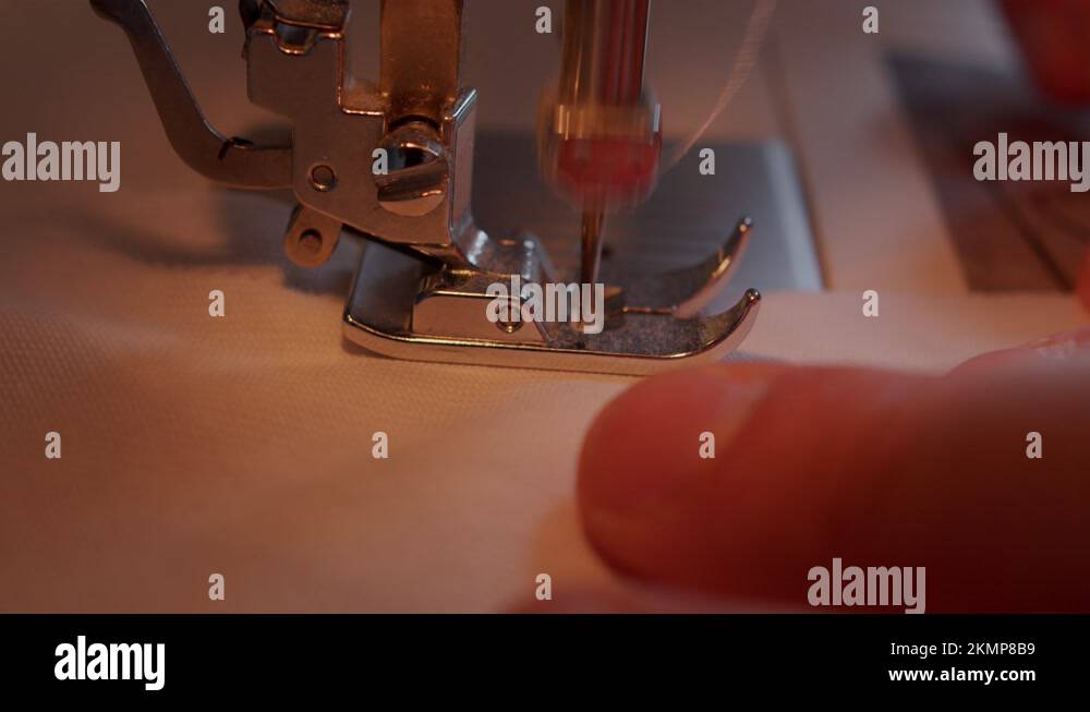 Close side view of needle moving through sewing machine foot into fabric Stock Video Footage Alamy