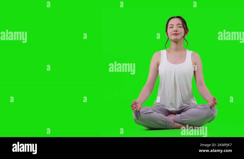 Young asian woman doing yoga. Mindfulness. Green background for chroma ...