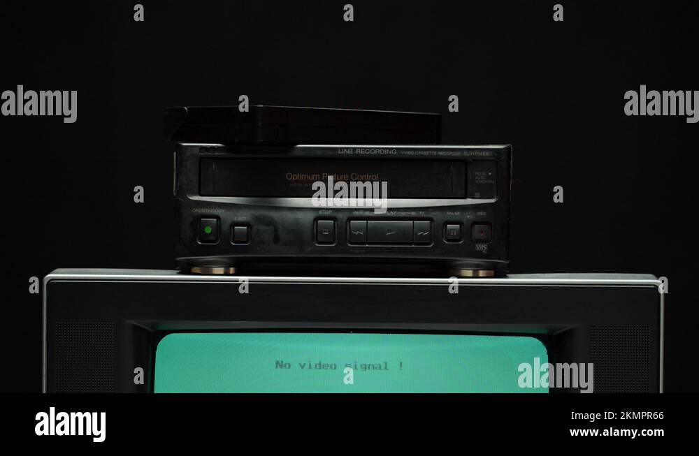 Taking video cassette into recorder. Old retro television with blue