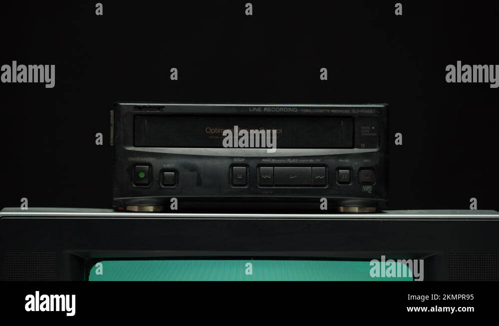 Taking video cassette from recorder. Old retro television with blue