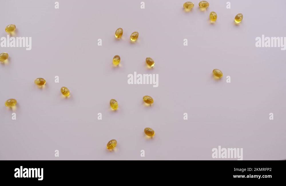 Vitamin D, omega, fish oil, yellow capsules, pills falling on a white