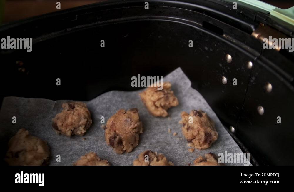 Pan out of raw chocolate chip cookie in air fryer, pull focus Stock