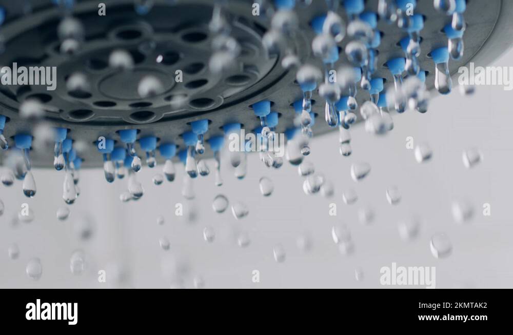 Drops of clear water dripping from the shower head. Super slow motion
