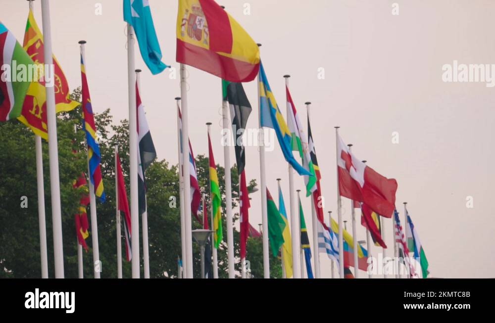 Flags of the countries of the world on flagpoles flutter in the wind