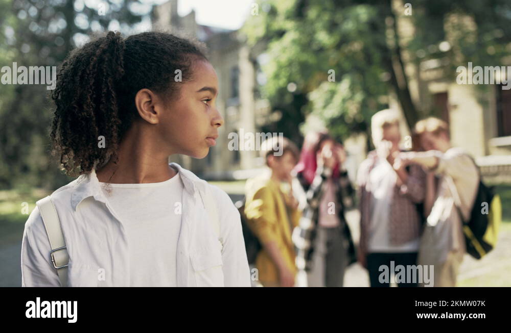 Group of school kids laughing at unhappy biracial girl, racial bullying problem Stock Video