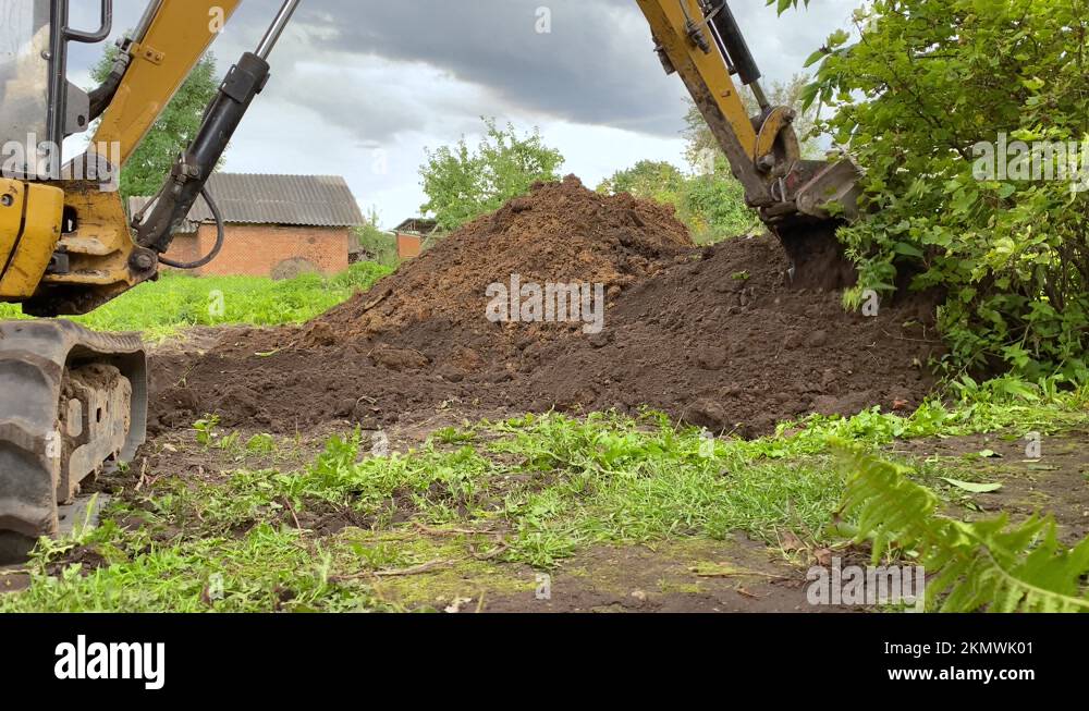 The excavator digs a hole with a bucket. An excavator bucket collects