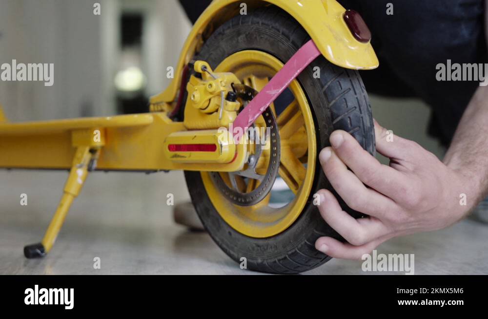Electric scooter repair The master checks the wheel of the