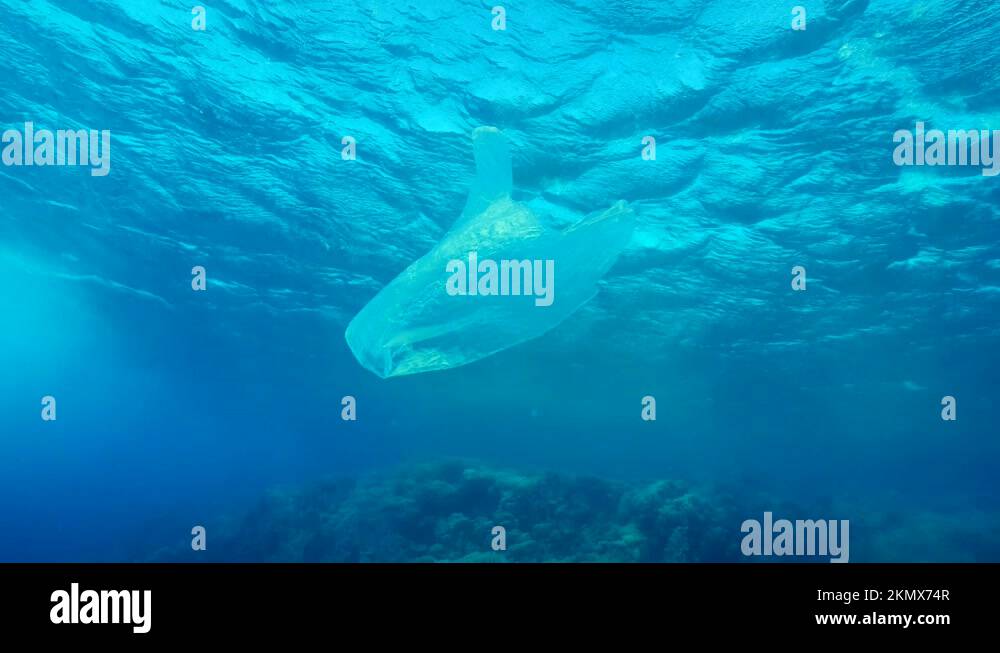 White plastic bag floats under waves in storm. Plastic pollution of the