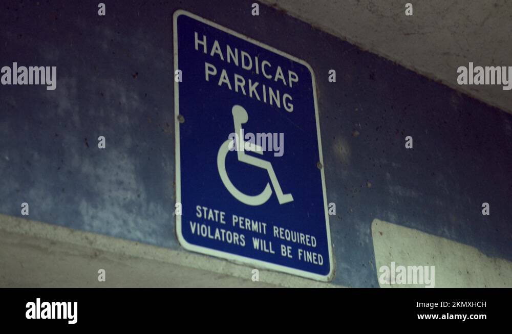 Handicap Parking Sign On The Concrete Wall Of A Parking Garage. close