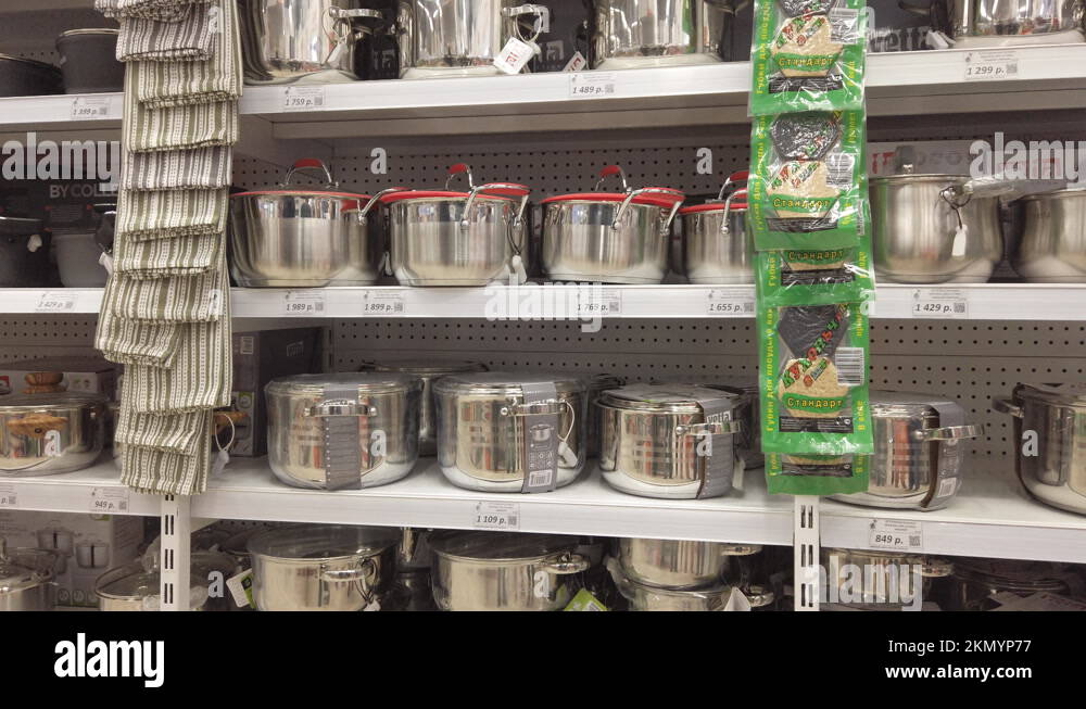 Various saucepans made of shiny metal on the shelves of the supermarket