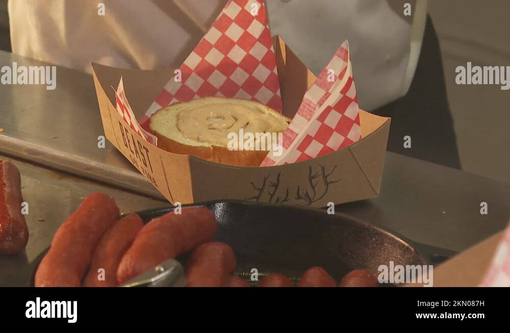 chef at a concession stand serving hot dogs and hamburgers onto