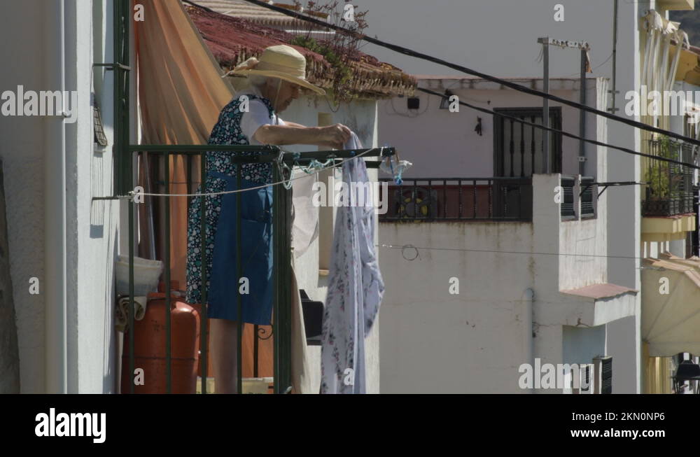 Older woman hanging freshly washed rags to dry on a balcony Stock Video ...