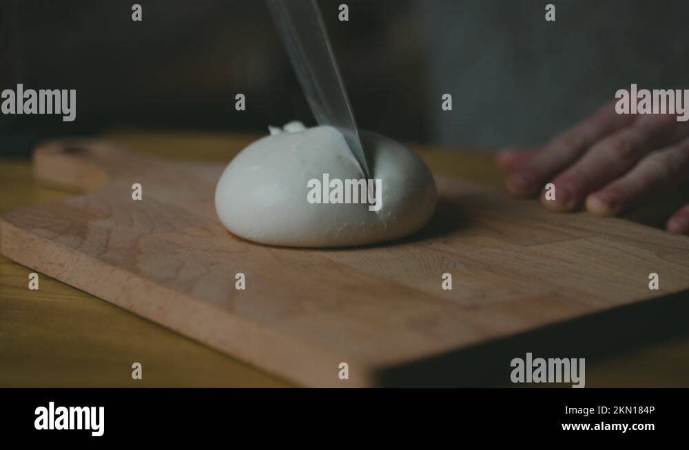 Cutting of soft traditional Burrata cheese, fluid oozes out Stock Video