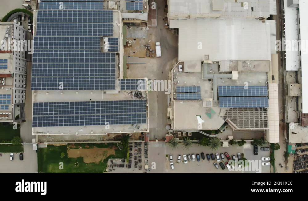 Photovoltaic Panels Rooftop Of Building In Karachi. Aerial Pedestal Up