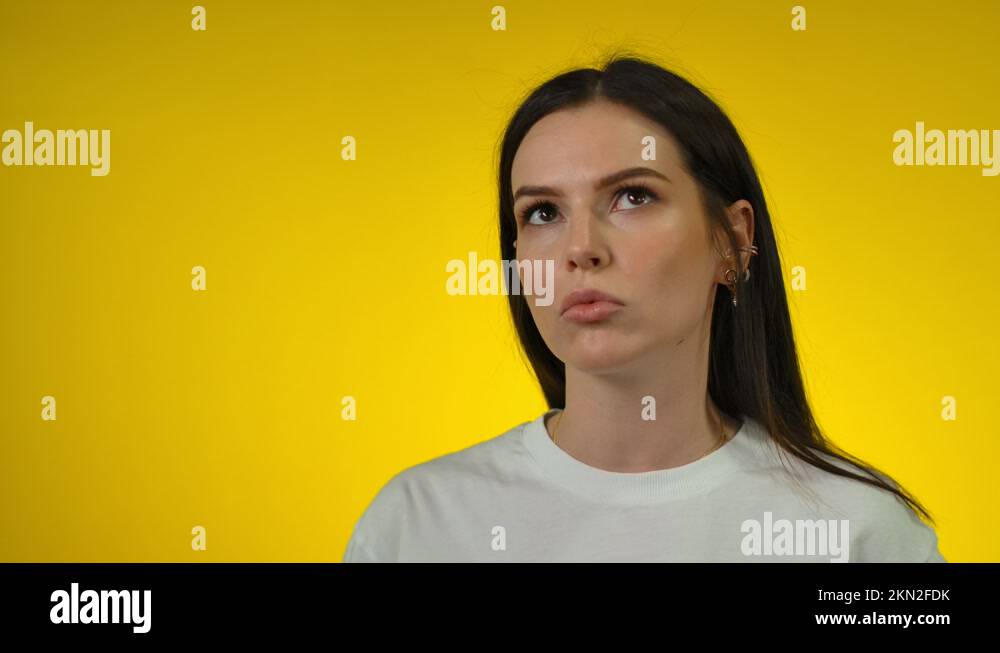 Thoughtful Young Long Haired Woman Looks Up And Thinks Deeply About