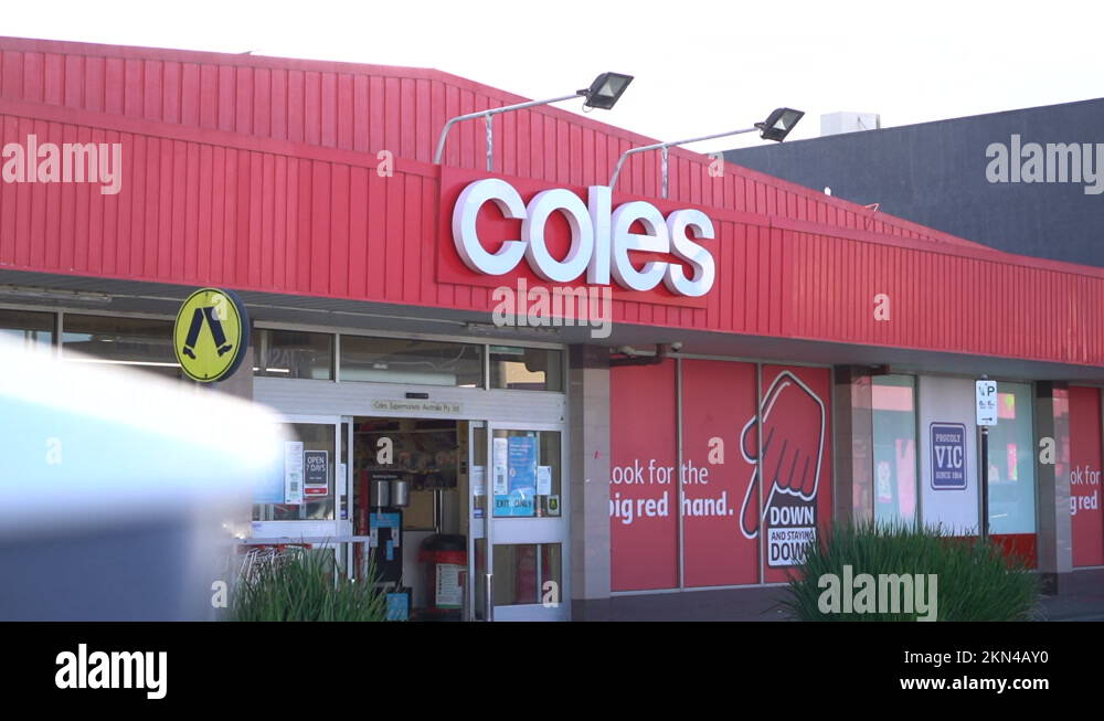 Coles liquor store logo sign on red building facade, motion view Stock