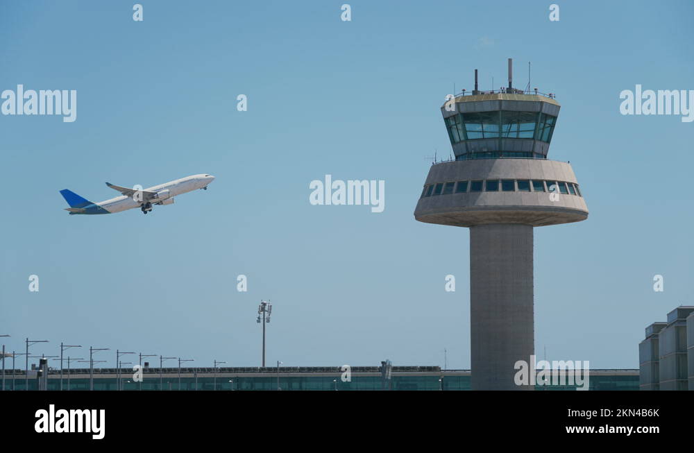 Blue airplane taking off next to an air traffic control tower Stock ...