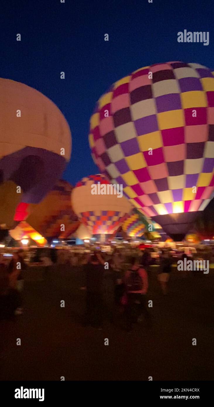 Colorful hot air balloons are tethered at the Central Harbourfront Event Space during the AIA Hong Kong International Hot Air Balloon Fiesta at dusk.