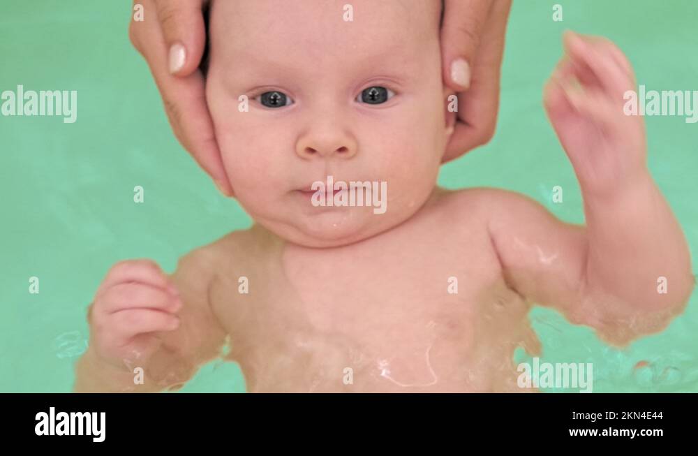 Mom teaches a newborn baby to swim and stay on the water. A twomonthold bab Stock Video