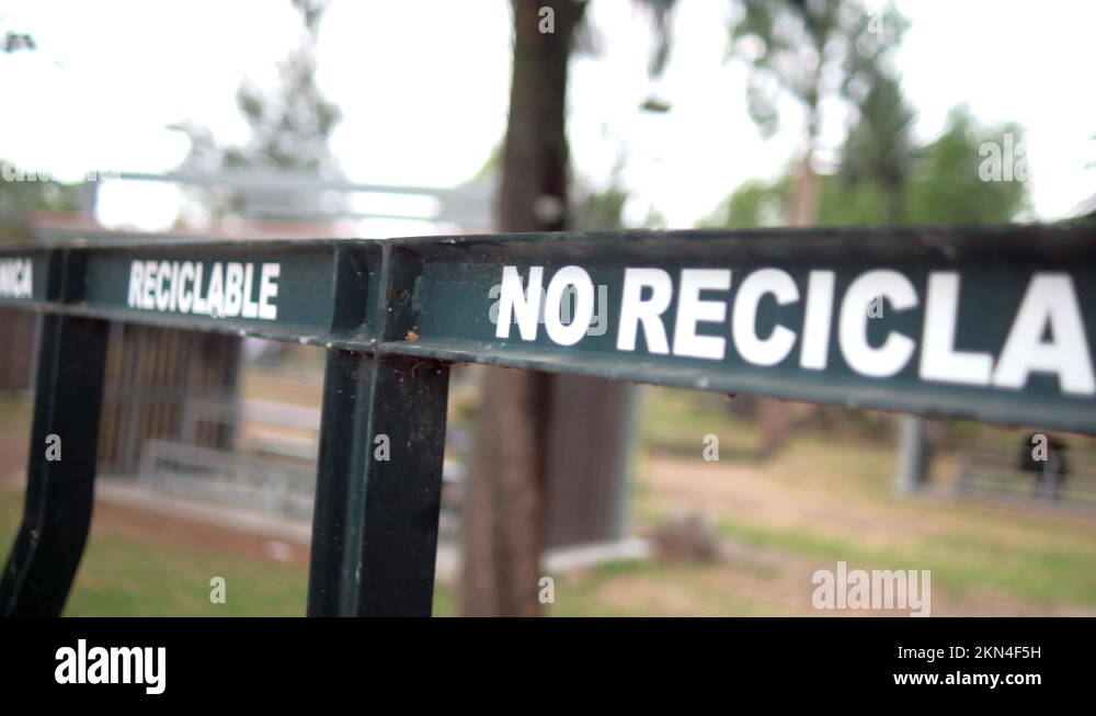 Spanish sign for recyclable and nonrecyclable trash with trees as
