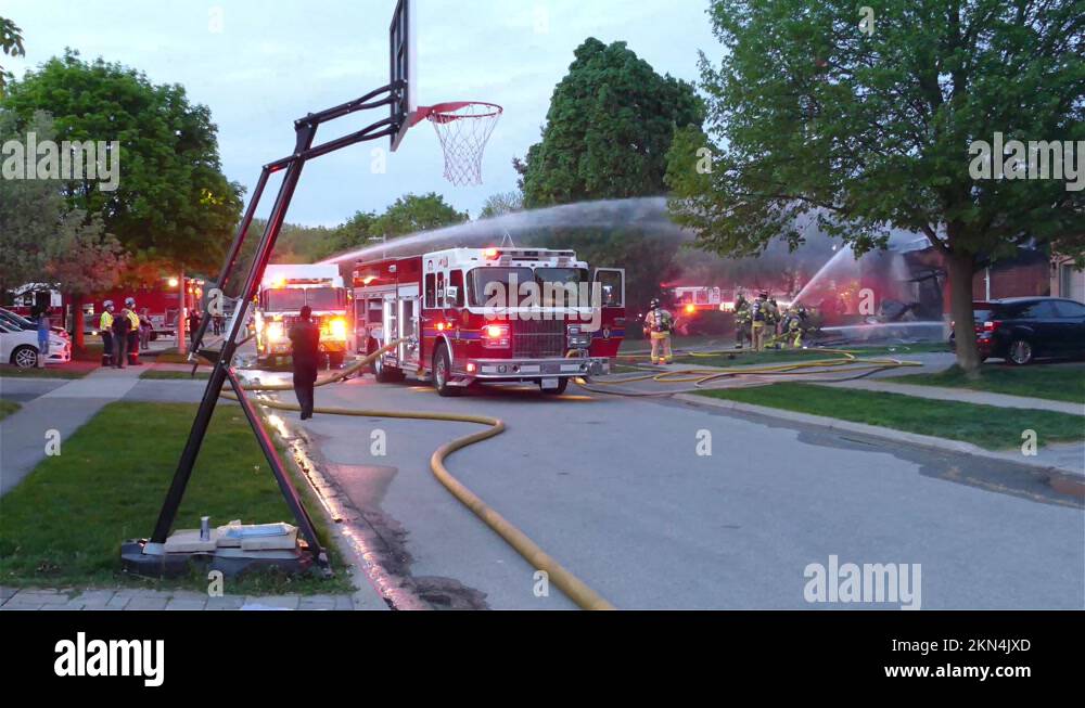Fire fighting at neighborhood house caught on fire, spraying water from