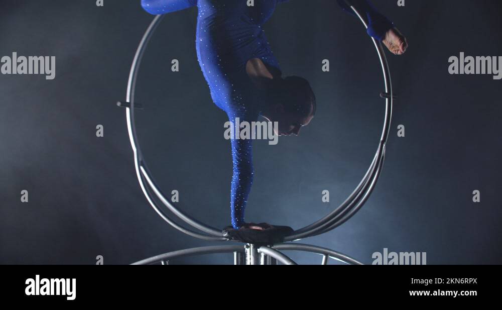 Upside down split on a spinning hoop by a flexible woman, gymnastics