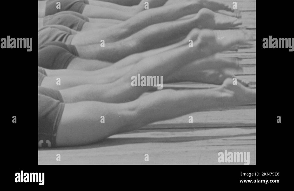 1940s People laying on stomachs on dock, kicking feet. Row of kicking