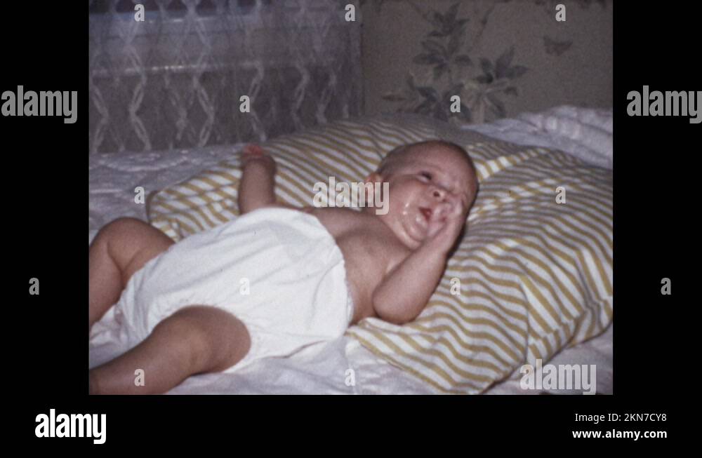 USA 1970s A baby in diapers is lying on the bed Stock Video Footage Alamy