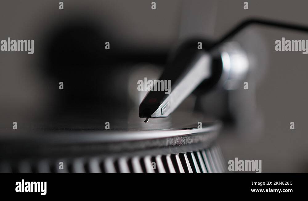 Male hand put needle on record spinning on turntable. Listening the