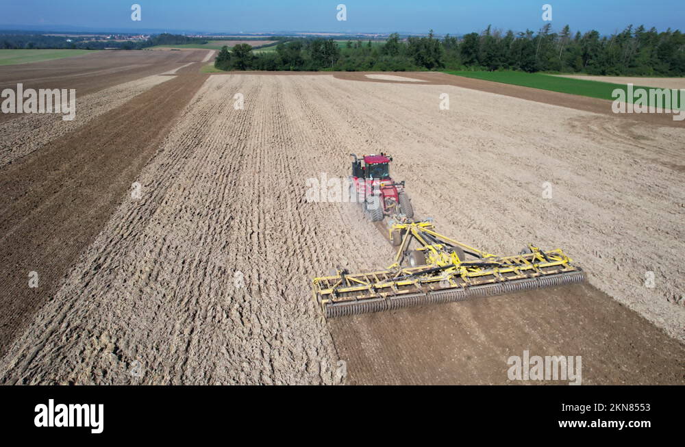 Harrowing a large field with a large crawler tractor. Soil cultivation