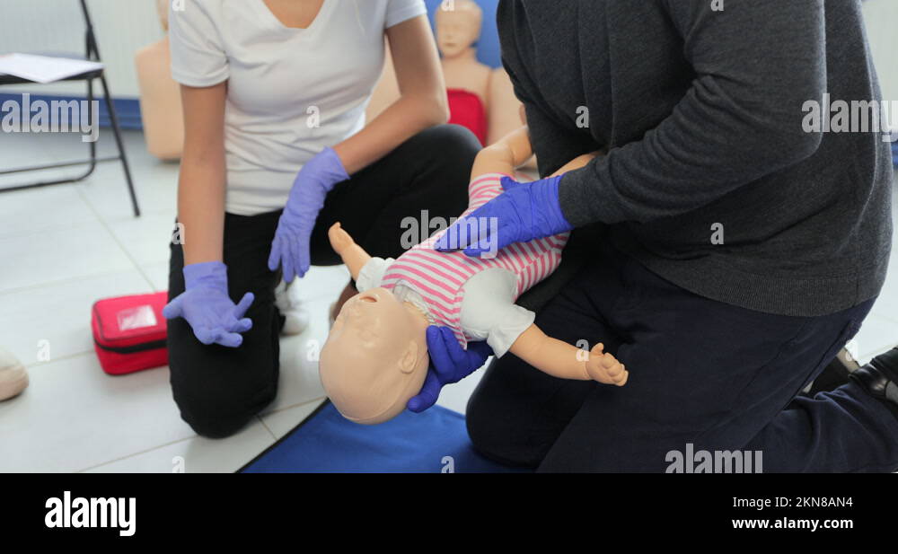 Closeup man learning how to make chest compressions on a baby dummy