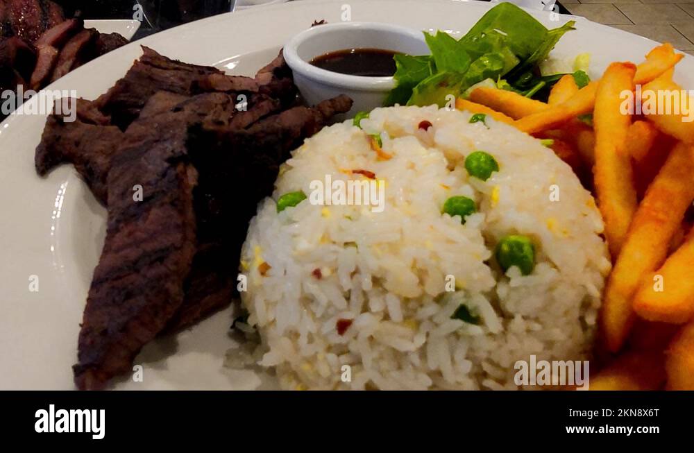 rotating plate of Manila Pilipino food grilled beef Baka Pares with