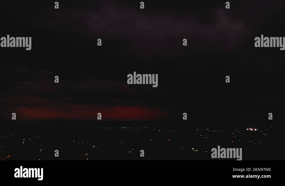 Sliding aerial footage of red clouds in sky with flashing lightning