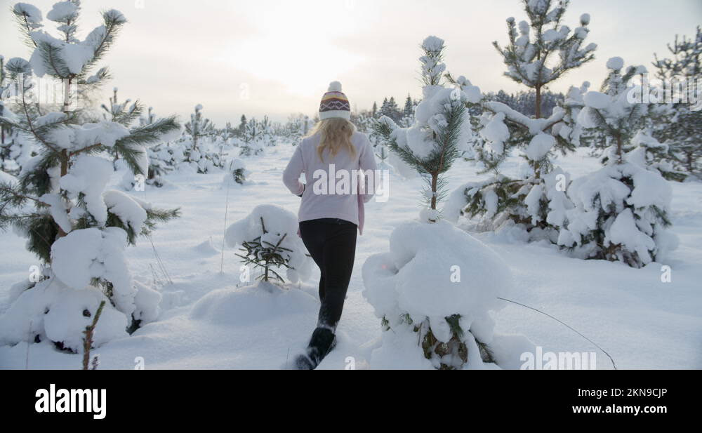 Woman walking hiking in deep snow in winter in nature slow motion