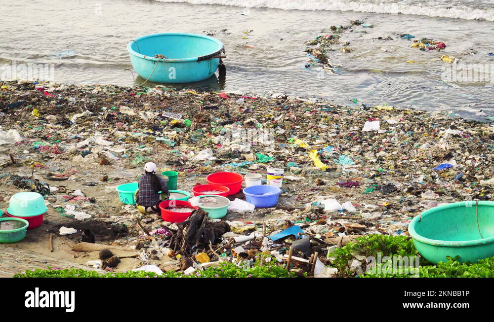 Polluted beach full of trash in Vietnam. Person walking. Static high