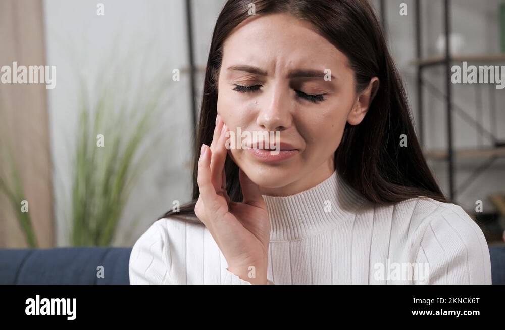 Woman touch cheek, suffers from toothache, terrible sudden tooth pain