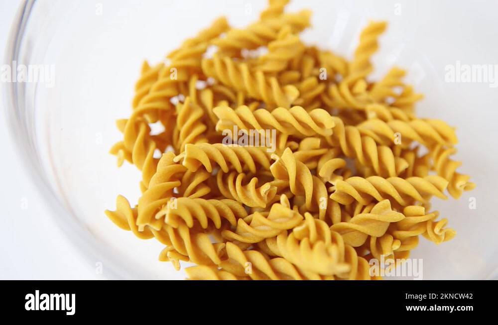 Whole grain dark yellow uncooked fusilli pasta. Italian macaroni