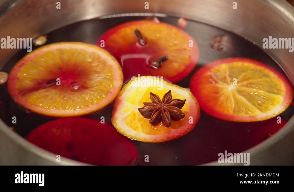 Cooking mulled wine, gluhwein recipe. Boiling red hot wine with apples