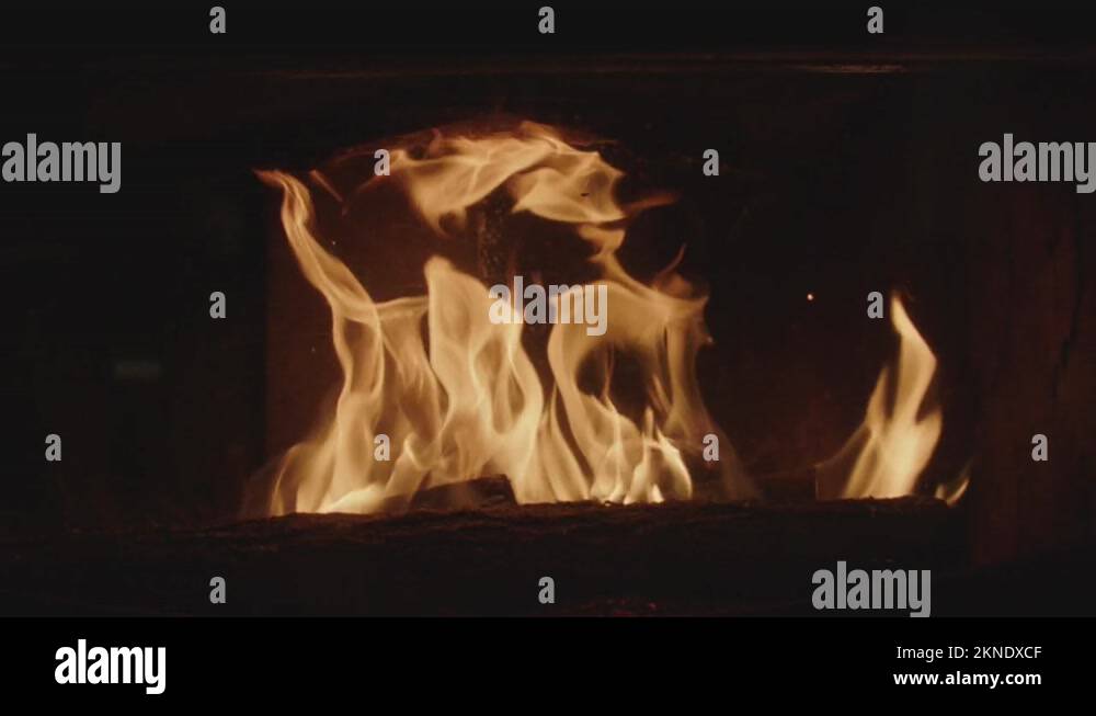 Flames and embers in slow motion inside a fireplace insert Stock Video