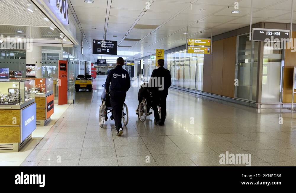handicapped passengers pushed on wheelchairs at munich airport, elderly