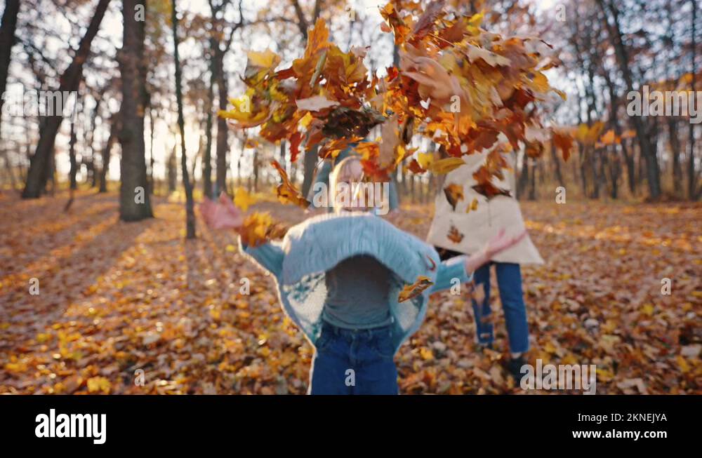 Young parents and their kid girl laughing, jumping and throwing up yellow Stock Video Footage