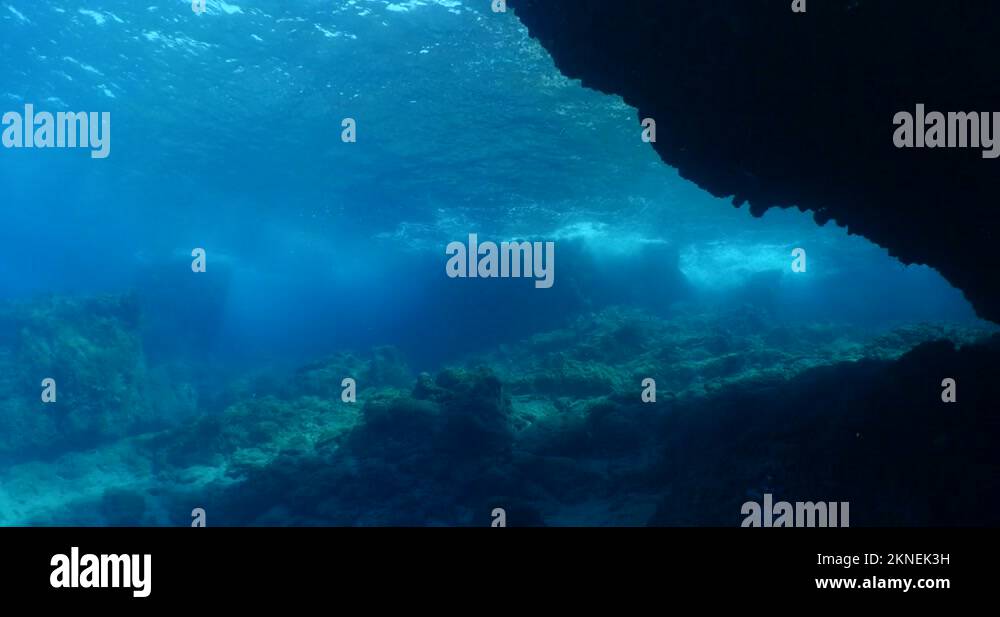 choppy water wavy sea underwater wave hit rocks and makes foam on the