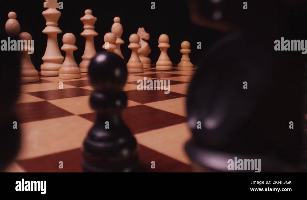 Camera moving through black chess pieces to zoom in on white chess