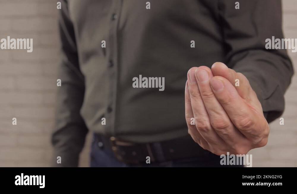 Closeup of a man rubbing his fingers against each other, depicting a